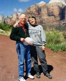 two people smiling and standing in desert